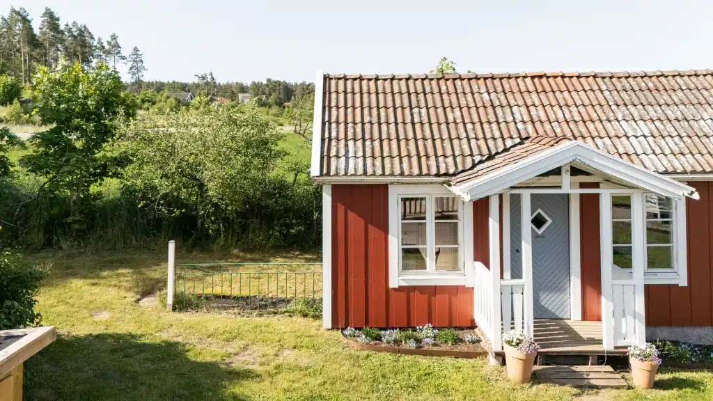 Hardie Plank fahatású sávos szálcement homlokzatburkolat piros házon