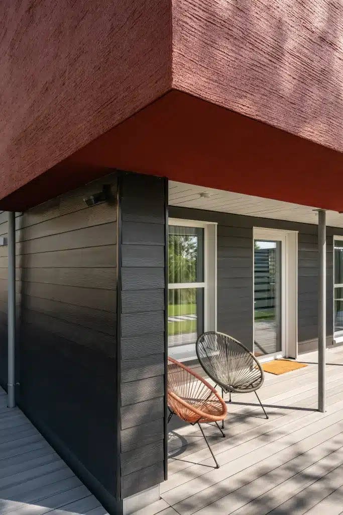 Hardie Plank fahatású szálcement homlokzatburkolat Midnight Black Cedar színben modern családi ház sarkán