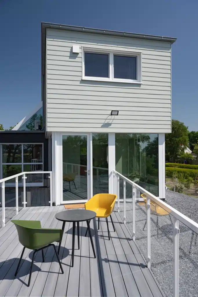 Hardie Plank fahatású szálcement homlokzatburkolat Soft Green Cedar színben modern családi házon